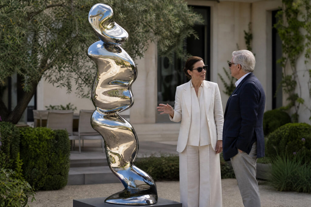 An art advisor and a collector discussing the emotional impact of a large-scale sculpture in a private garden.