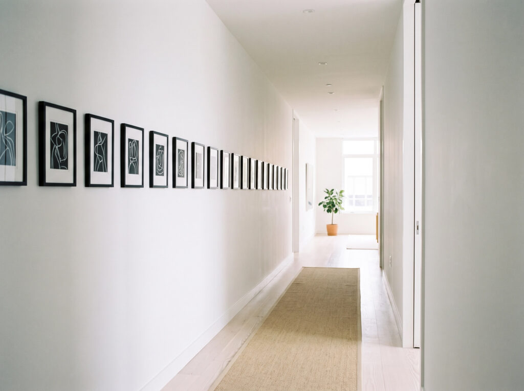 Minimalist Art and Slow Living: A minimalist hallway with rhythmic artwork placement.