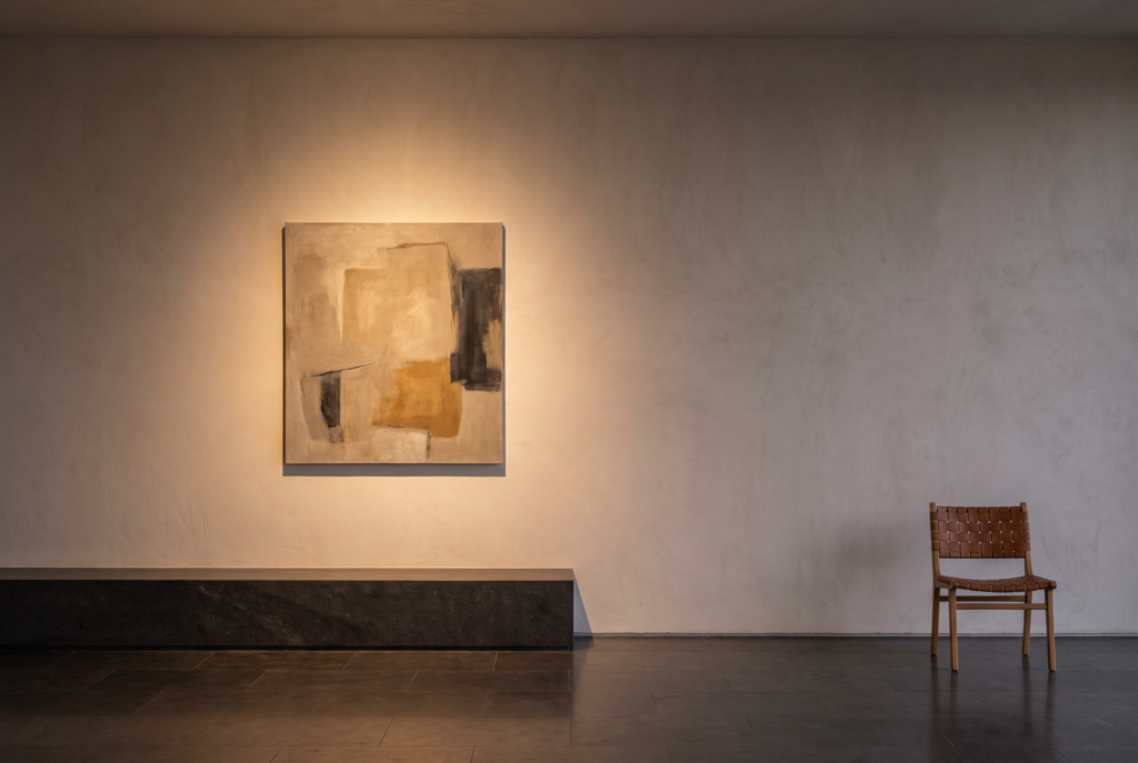 A collector thoughtfully reviewing artwork details and budget notes beside a small original work.